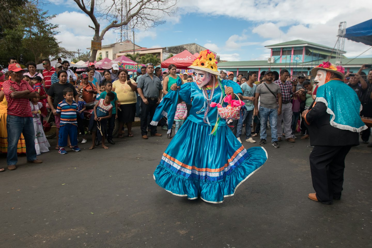 Folklórni tanečníci v pestrofarebných krojoch vystupujú na pouličnom festivale.
